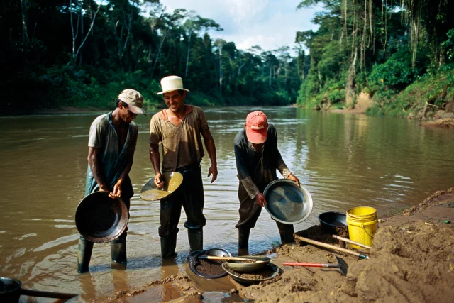 3 orpailleur clandestins le long d'un cours d'eau en Guyane