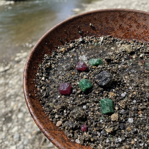 Vue rapprochée d'une batée rouillée avec des gemmes potentielles.