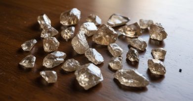 Pierres précieuses non taillées posées sur une surface en bois.