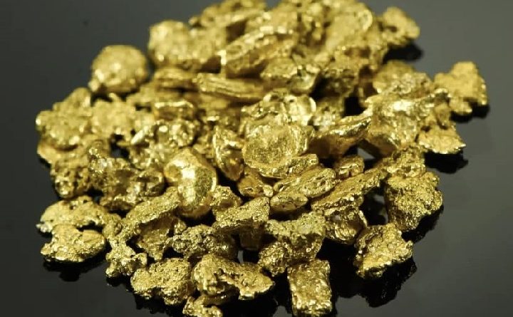 ensemble de pépites et de paillettes d'or posé sur une table noire