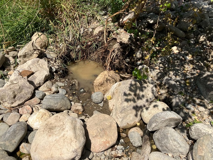Trou creuse par des orpailleurs et laisse non rebouche rempli d eau boueuse sur la berge d une riviere du Gard